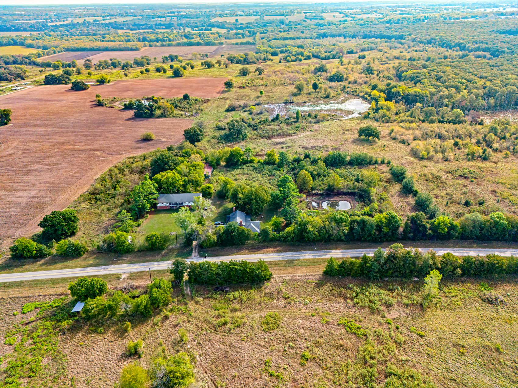 Drone aerial photo of the site today in Paris, Lamar County, Texas: pasture, trees, ponds and the house on the land